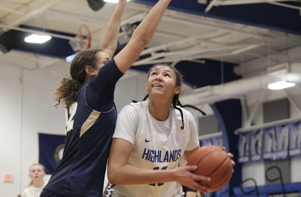 Marissa Green (12) protects the ball as she drives to the basket to shoot a layup.